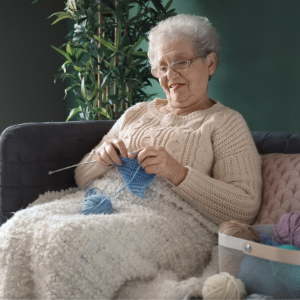 Old woman knitting in warm