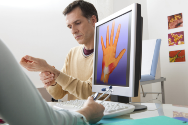 Patient holding wrist with doctor