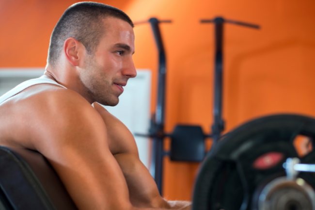 Proximal Biceps Tears Man in gym with big biceps lifting weights