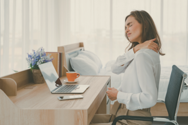 Frozen Shoulder FAQs Woman at desk holding shoulder in pain