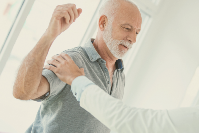 Dislocated Shoulder Diagnosis Treatment Doctor holding man's shoulder