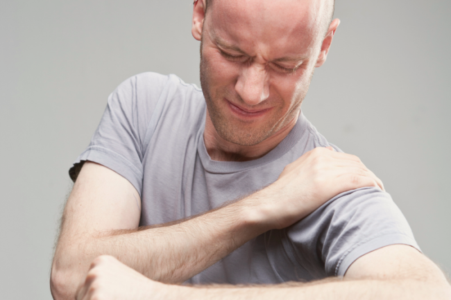 Shoulder Impingement Man holding shoulder in pain