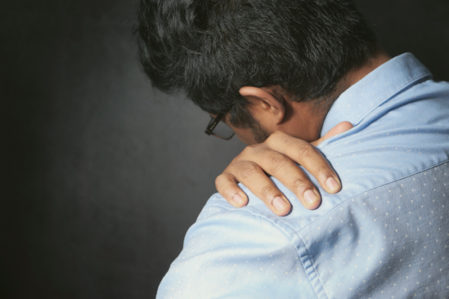 Shoulder Clicking Man holding shoulder