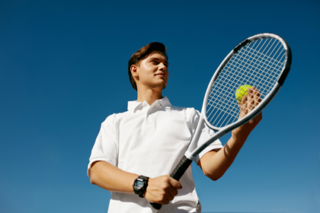 Avoiding summer sporting shoulder and elbow injuries Man with tennis racket with blue sky background