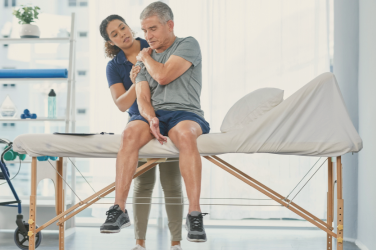 Glenohumeral Arthritis About Diagnosis Symptoms and Treatment Middle aged man sitting holding shoulder with physiotherapist