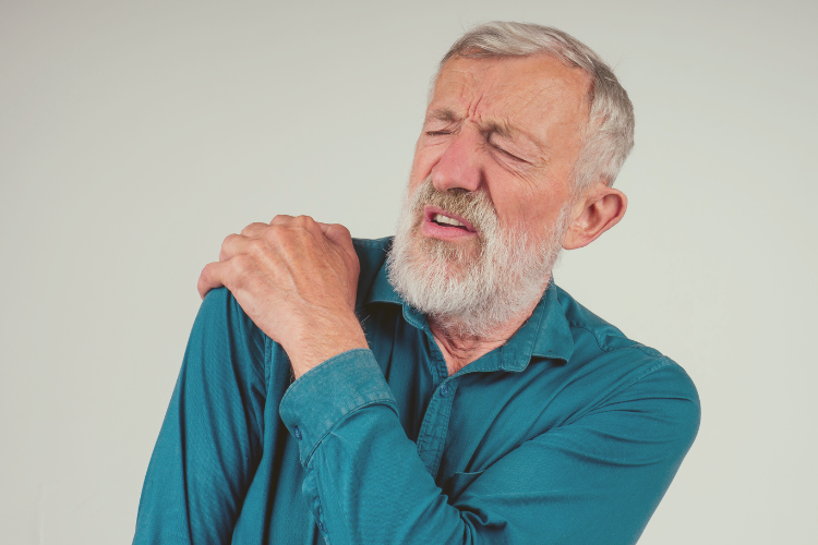 Older man holding shoulder in pain