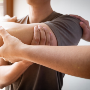 Man with rotator cuff tear being treated by physiotherapist